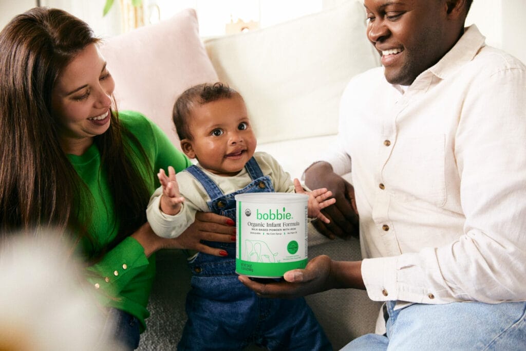 Parents and baby with can of Bobbie Organic Infant Formula
